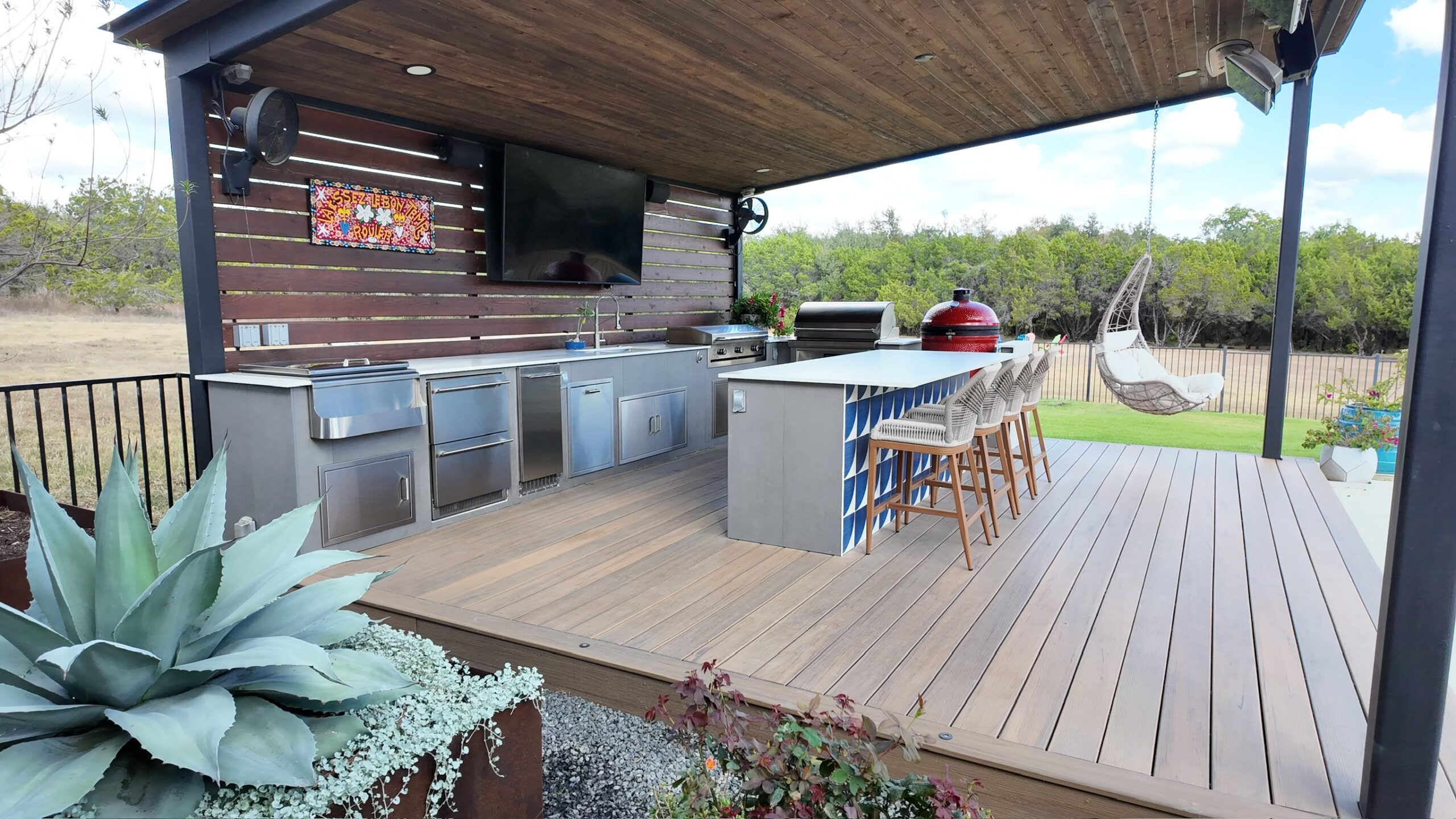 Luxury outdoor kitchens in Austin, TX under a cedar pavilion with porcelain counters and built in grill