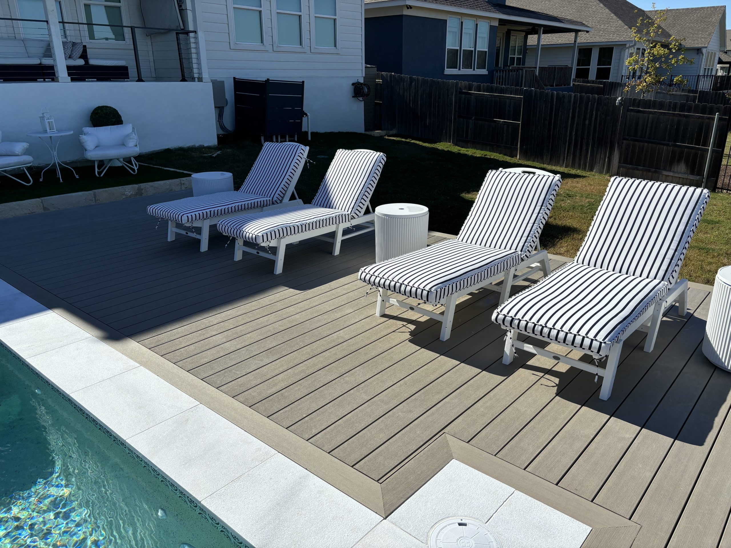 composite-decking-Austin-TX Composite decking in Austin, TX backyard with native landscaping and modern outdoor seating. Composite decking Austin TX